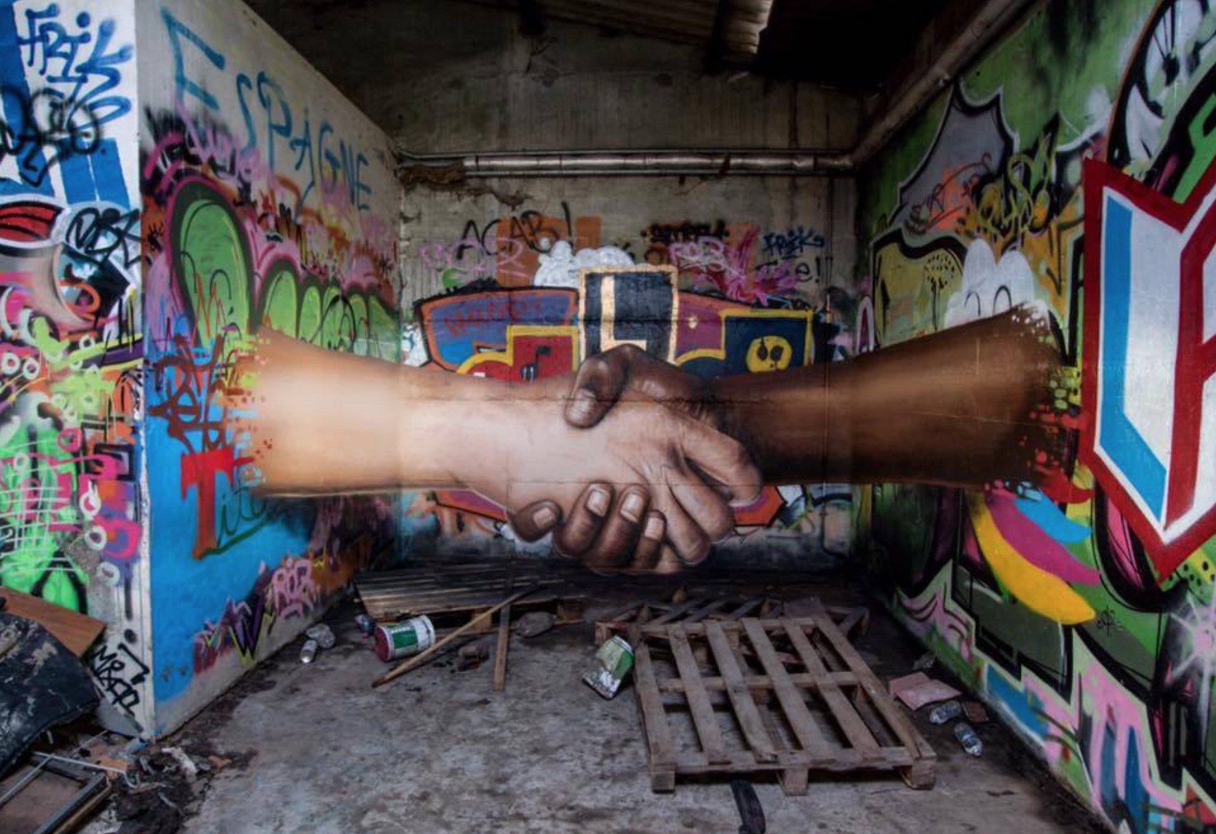 A mural of a black hand and white hand holding hands