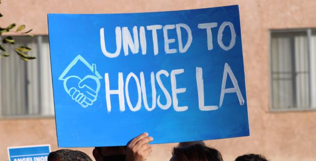 Handpainted poster reading "United to House LA"