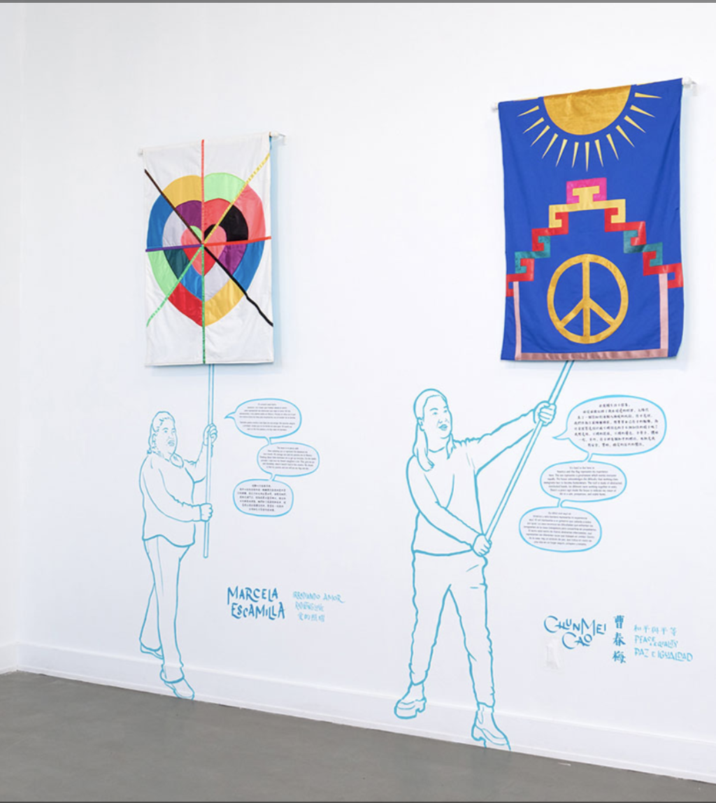 Image shows two colorful banners inside an art gallery on white gallery walls 