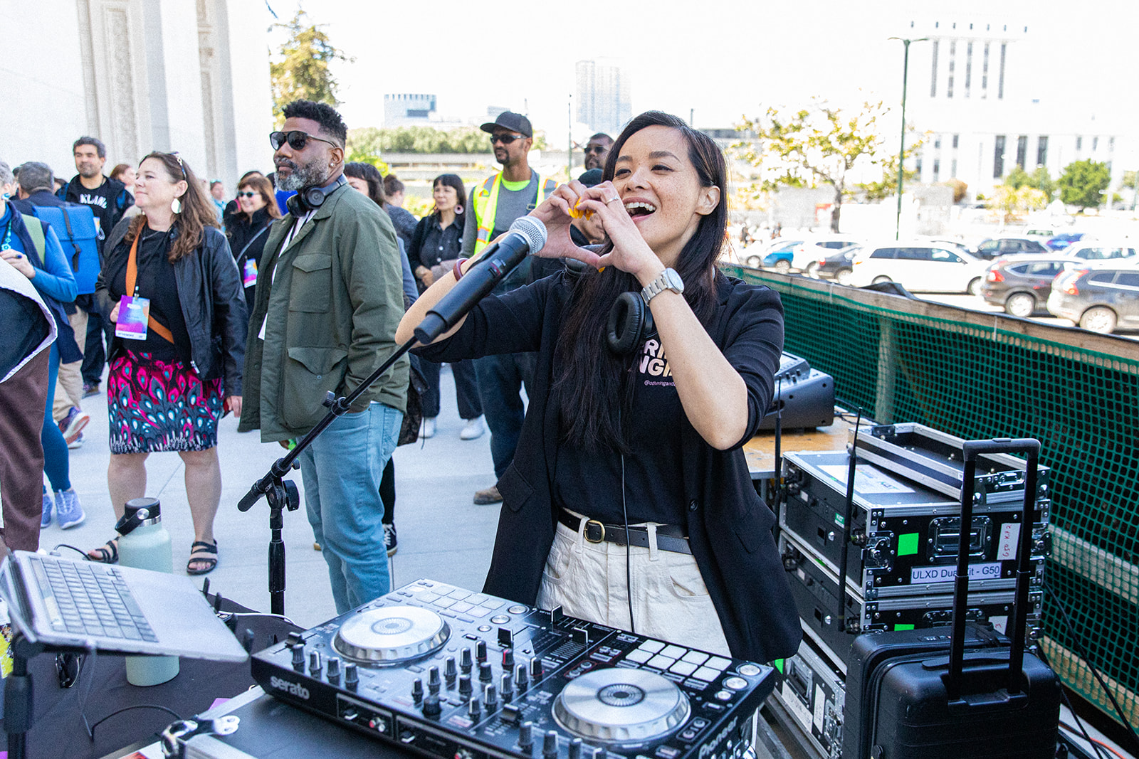 A young woman DJ makes a heart gesture with her hands