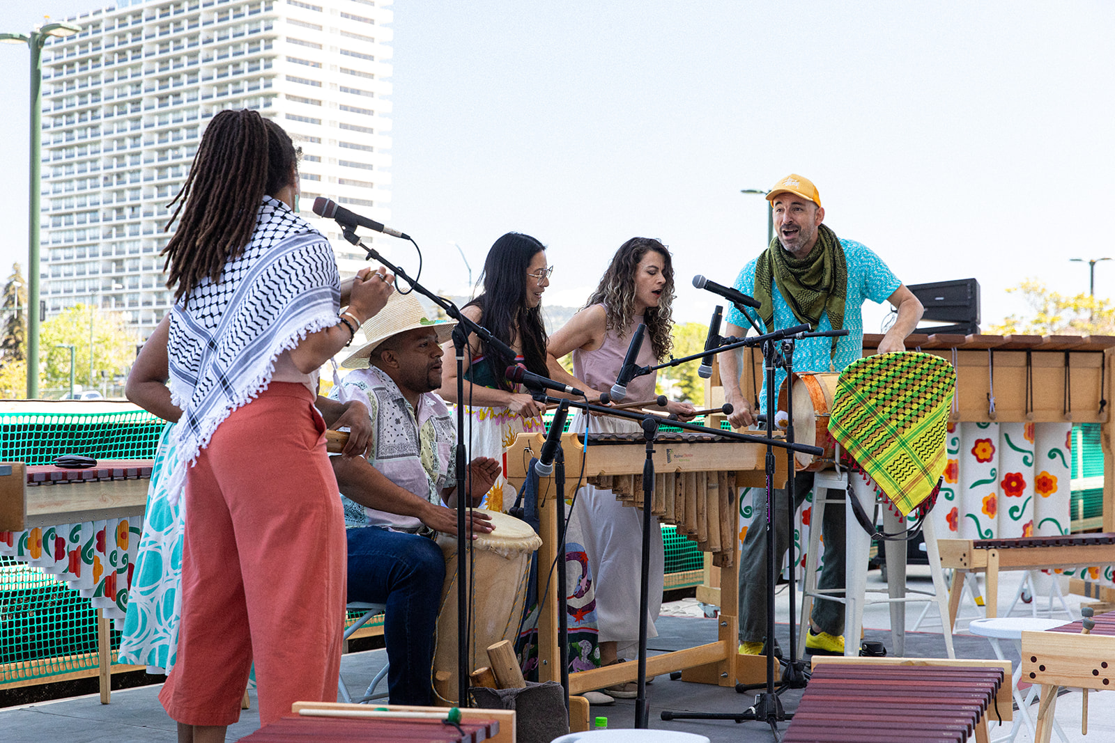 A band plays percussive instruments on an outdoor deck