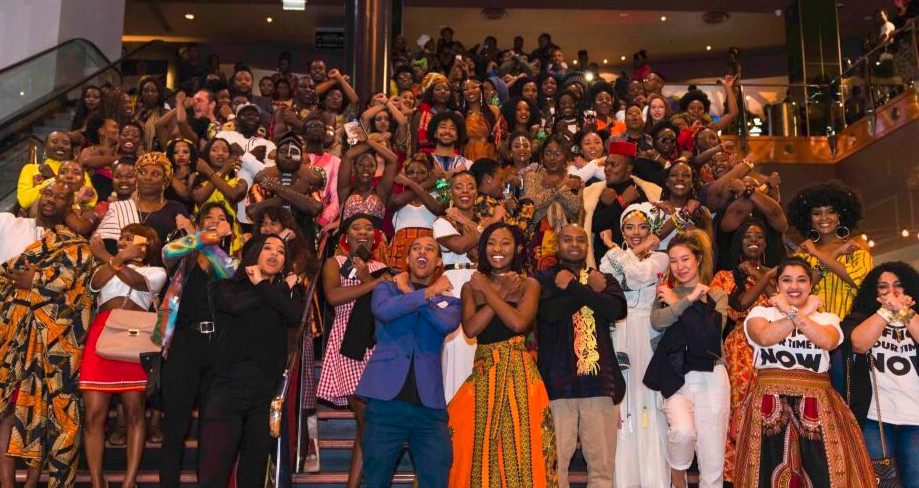 Photo by Emmanuel Mbala, The crowd at a Melbourne screen- ing of Black Panther, doing the Wakanda greeting. 2018