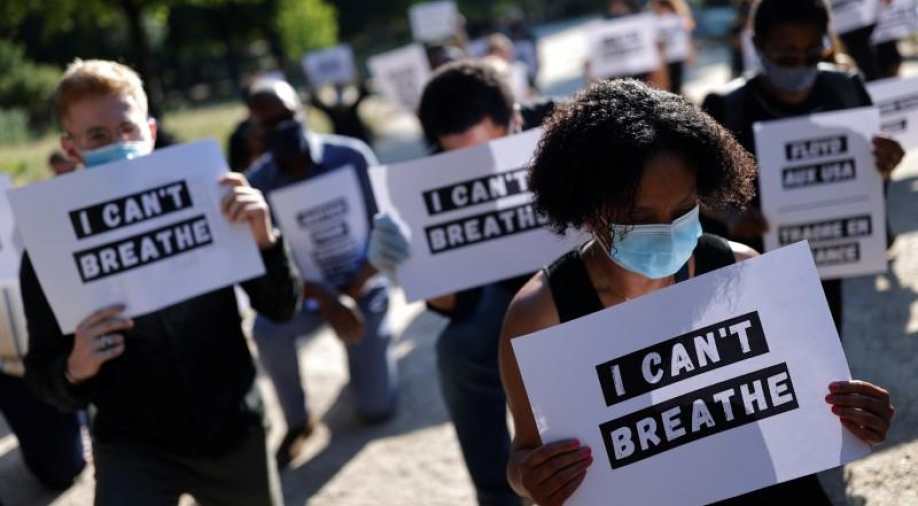Protesters wearing masks and holding "I cant breathe" signs