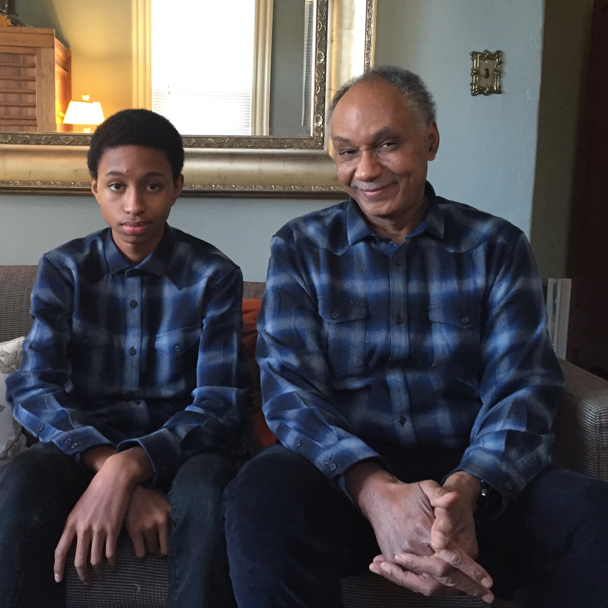 Tyler Stovall seated with his son, Justin, wearing the same outfit
