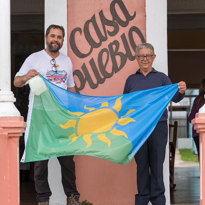 Arturo and his father holding the Casa Pueblo flag