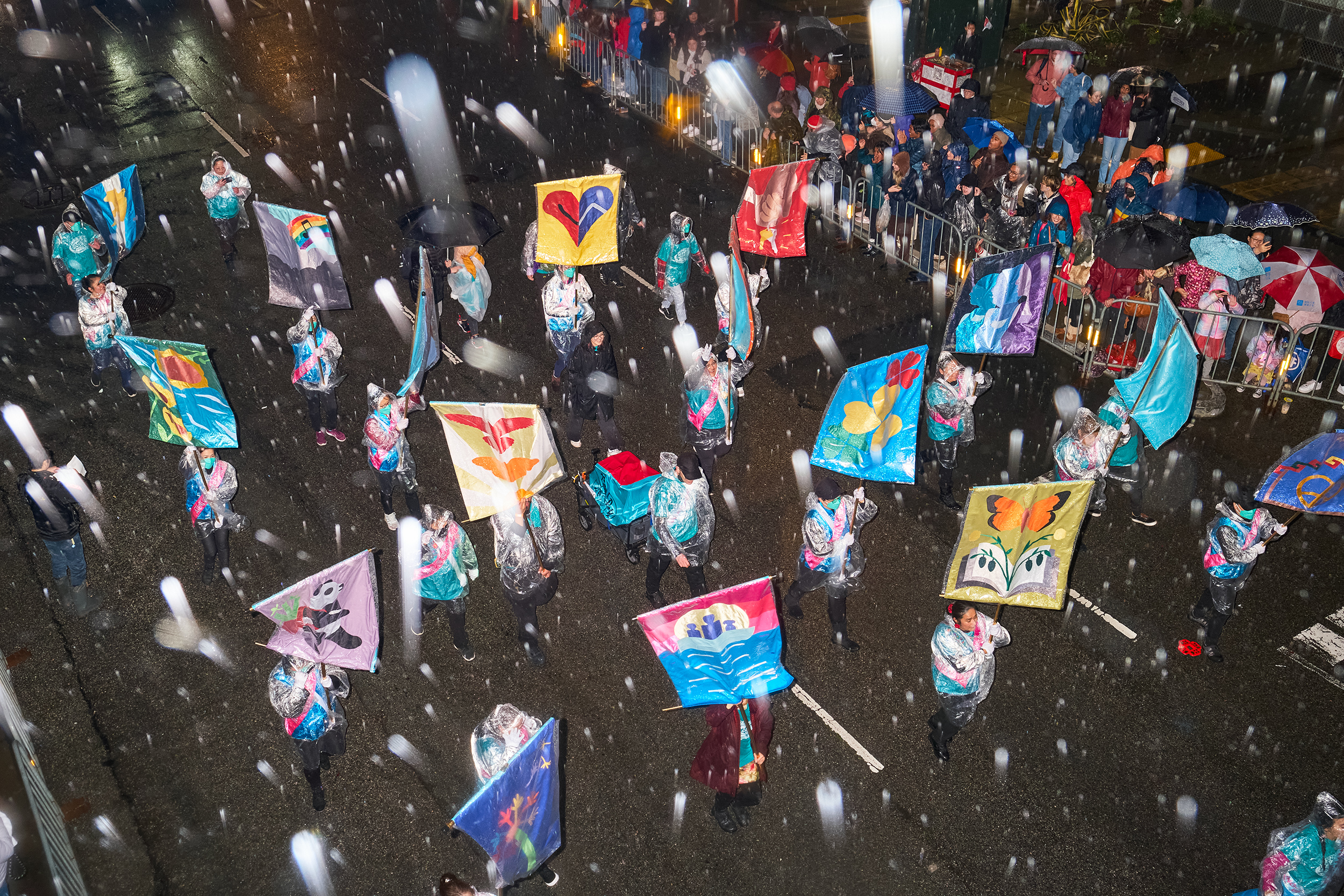 Aerial image of people holding colorful banners in a parade 