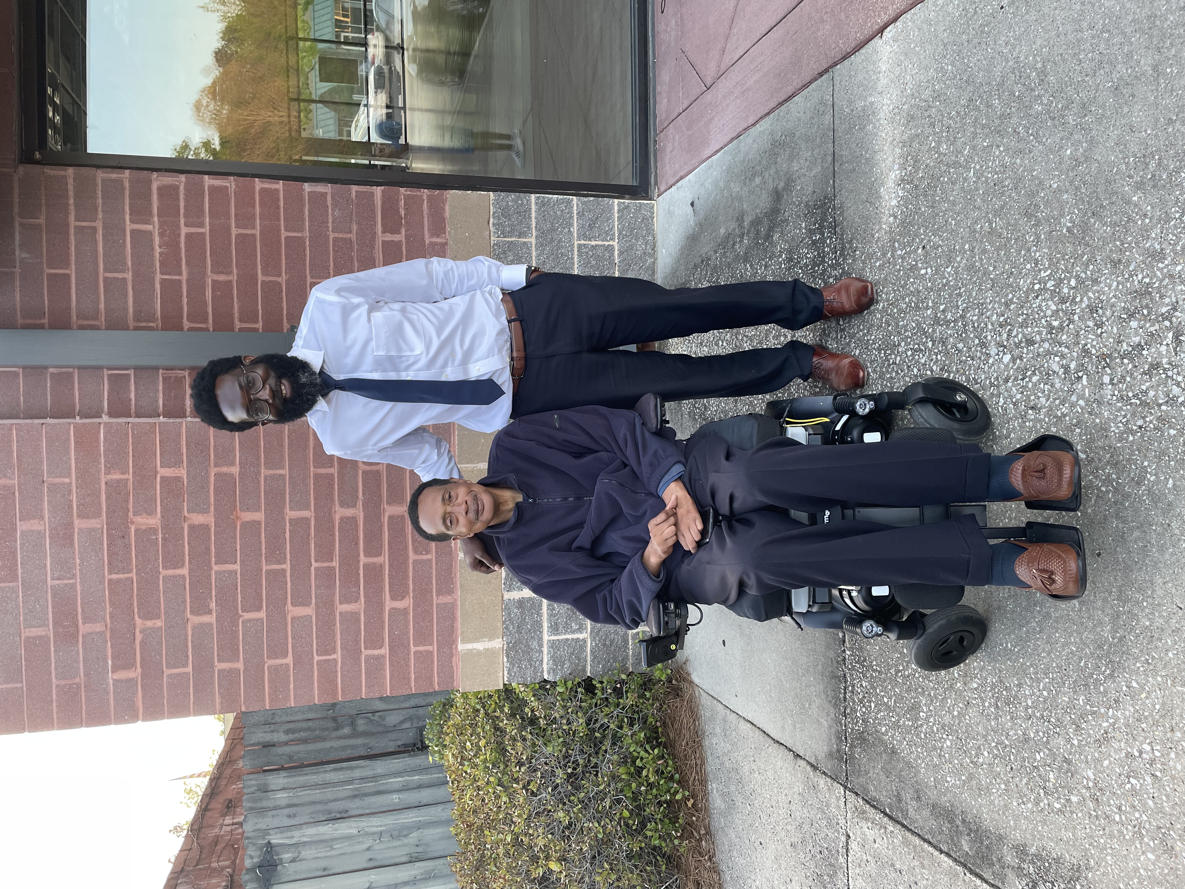 Shamichael Hallman standing with his father Michael Hallman who is in a wheelchair.