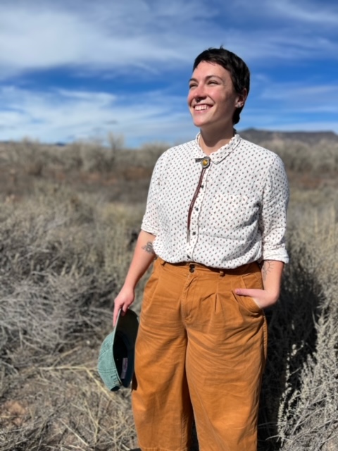 Julia McKeown standing in a field looking off into the horizon.