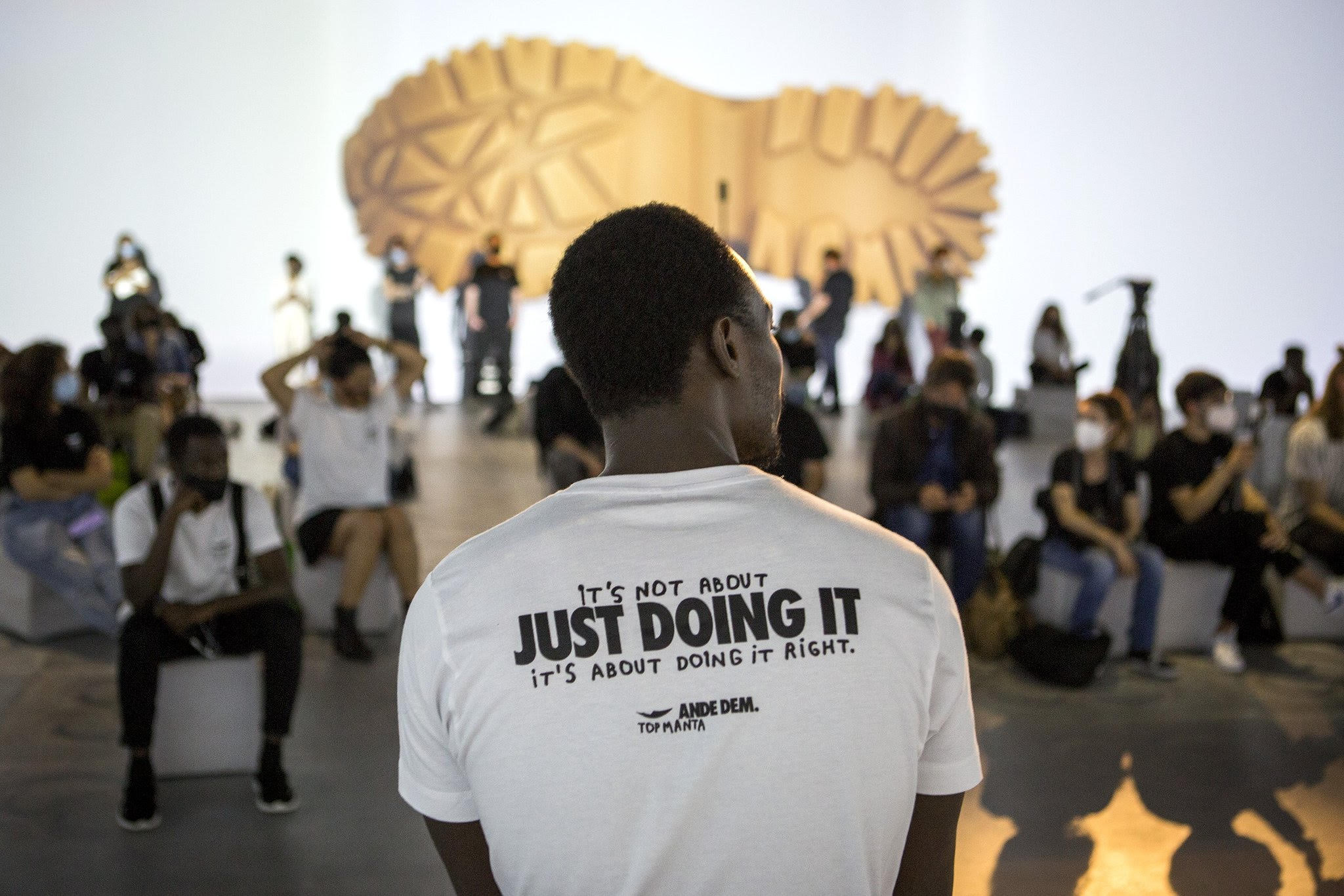 A Black man wearing Top Manta gear that reads "It's not about just doing it, it's about doing it right."