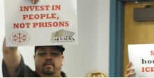 This picture is of Johnny holding a sign titled "invest in people, not prisons" 