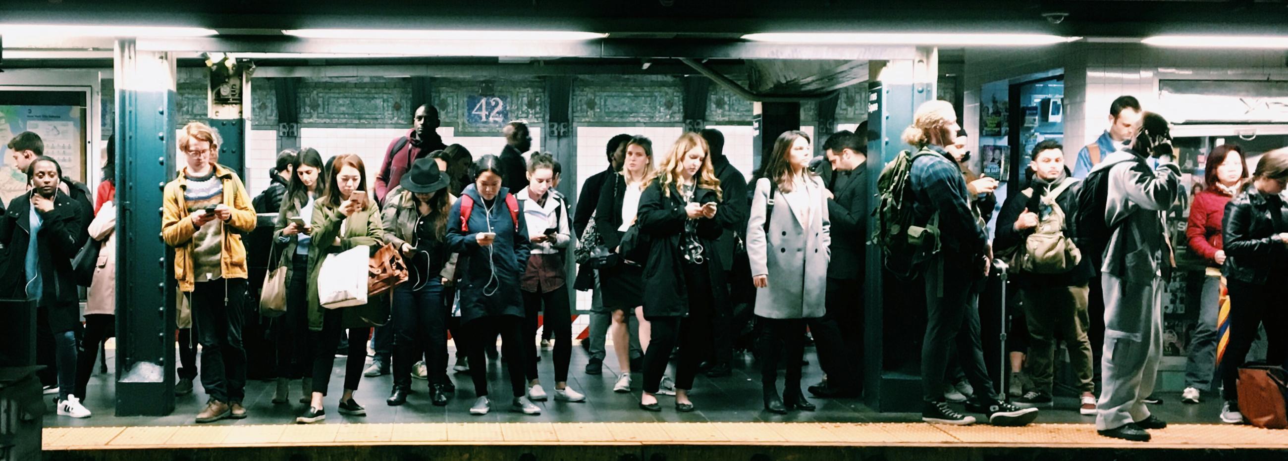 People waiting on a platform at New York subway (photo by Eddi Aguirre)