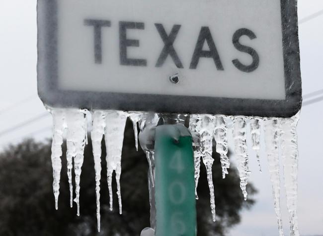 A sign reading texas covered in ice and Icicles