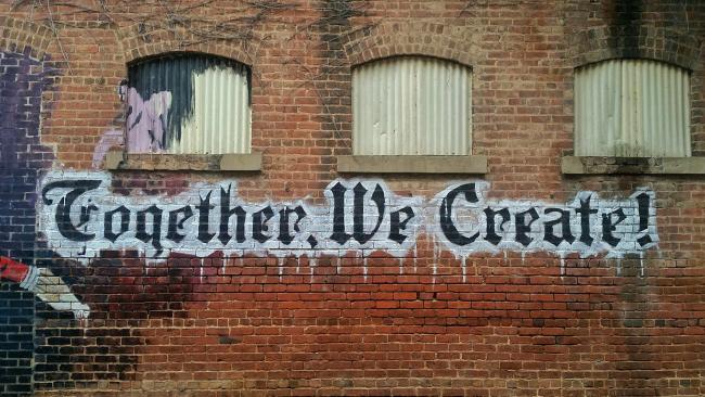 A mural that reads, "together, we create"