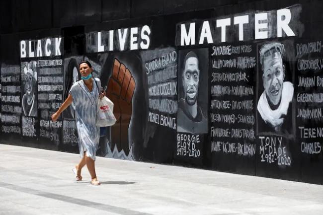 Person walking past a Black Lives Matter mural
