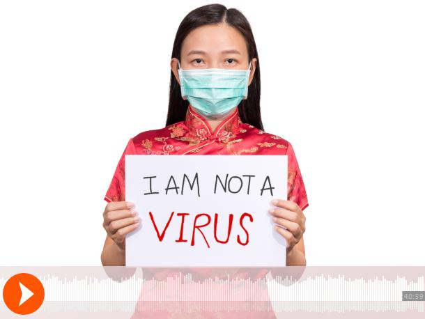 Photo of an Asian woman holding a sign that reads "I am not a virus"
